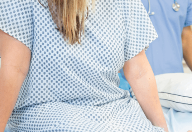 heart and vascular institute - woman wearing hospital gown sitting on hospital bed