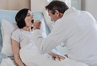 doctor checking woman's throat