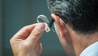 Man putting in a hearing aid