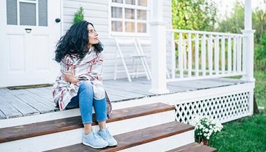 woman sits on step thinking