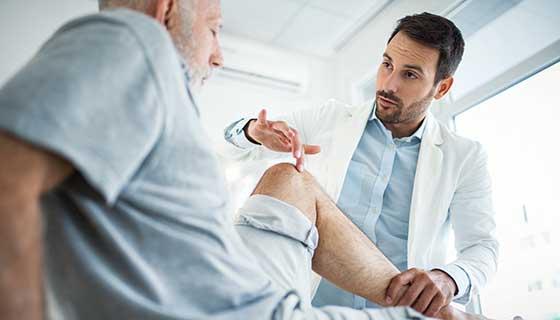 Doctor pointing to patient's knee.