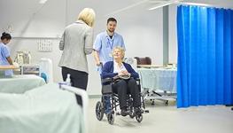 woman in wheelchair leaving hospital