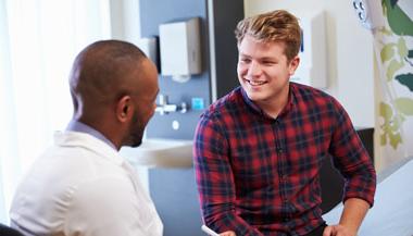 Young man speaking with doctor in doctors office