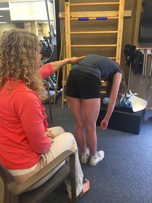 Robin performs the scoliosis test on Sophie