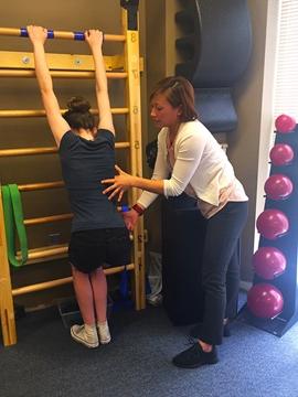 Lien assists Sophie with Schroth exercises