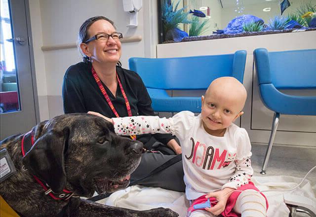 a child and doctor enjoy pet therapy