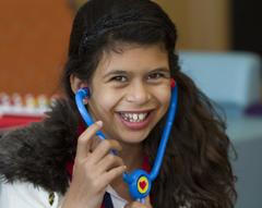 A girl playing with a toy stethoscope